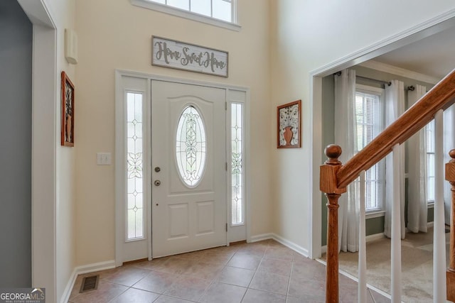 foyer entrance featuring ornamental molding and light tile patterned floors