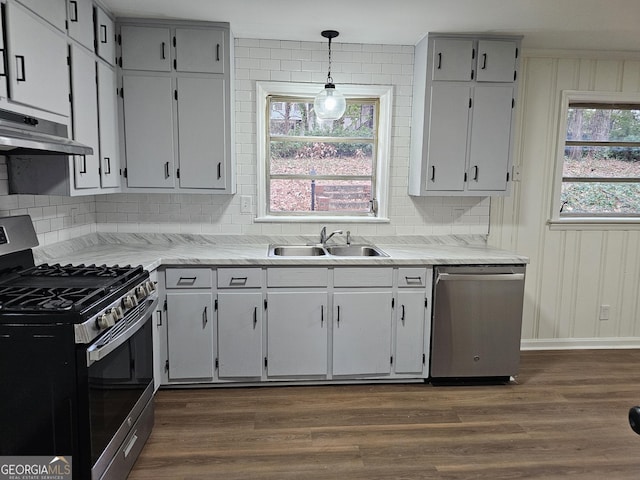 kitchen featuring gray cabinetry, stainless steel appliances, sink, light hardwood / wood-style flooring, and hanging light fixtures