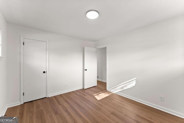 unfurnished bedroom featuring wood-type flooring and a closet