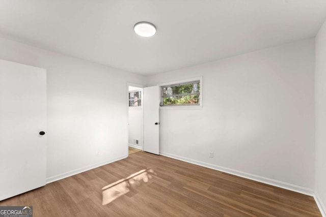 unfurnished room with wood-type flooring