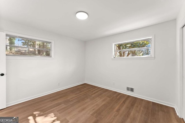 unfurnished room featuring dark wood-type flooring