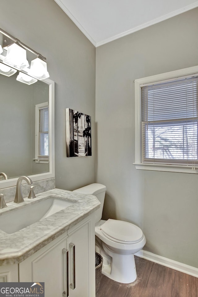 bathroom featuring hardwood / wood-style floors, vanity, toilet, and crown molding