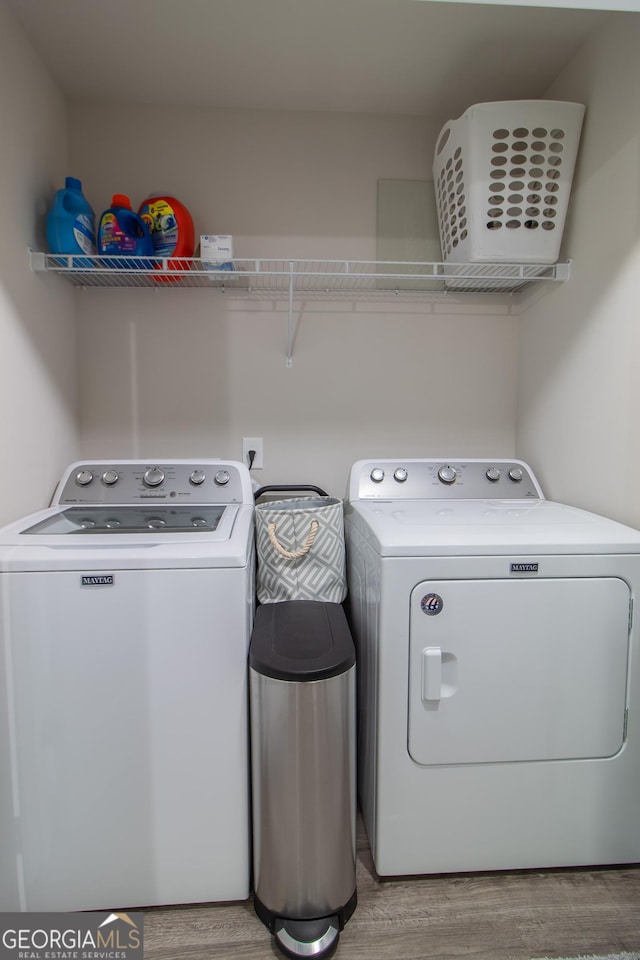 clothes washing area featuring washer and dryer and light hardwood / wood-style flooring