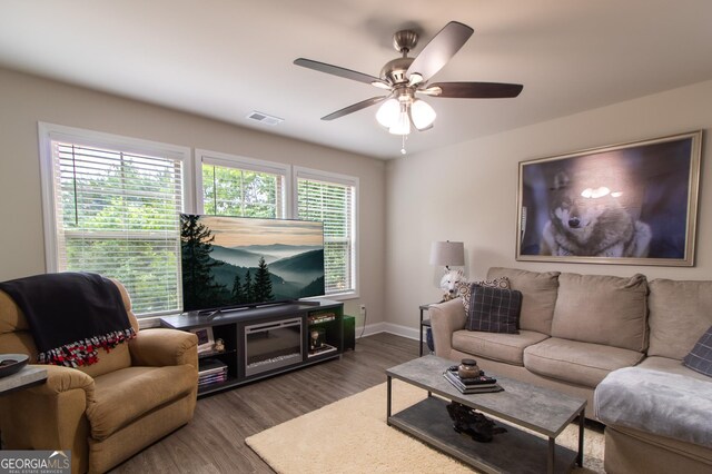 living room with ceiling fan and dark wood-type flooring