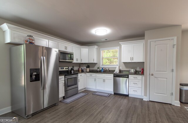 kitchen featuring sink, white cabinets, stainless steel appliances, and dark hardwood / wood-style floors