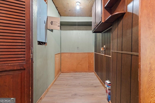 corridor with electric panel and light wood-type flooring