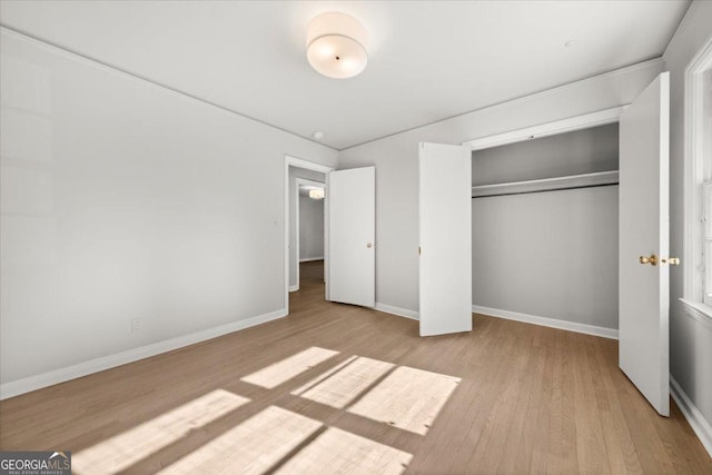 unfurnished bedroom with light hardwood / wood-style flooring and a closet