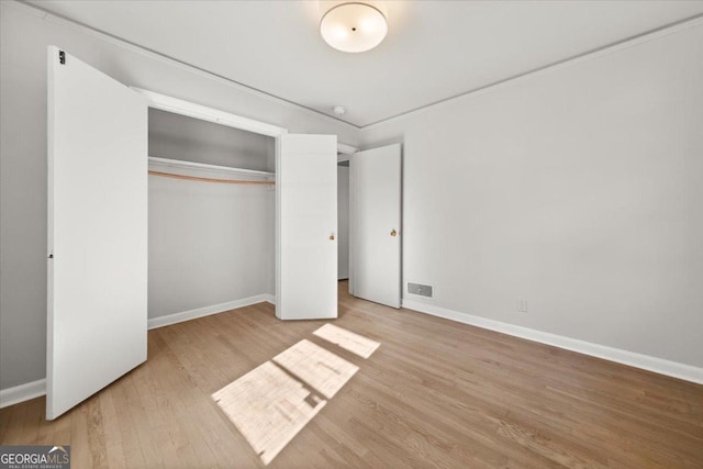 unfurnished bedroom with light hardwood / wood-style floors and a closet