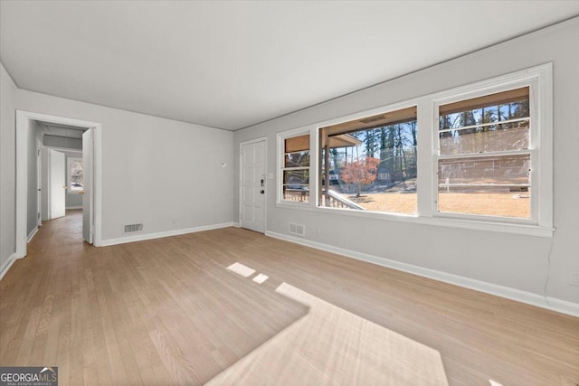 empty room with light hardwood / wood-style flooring