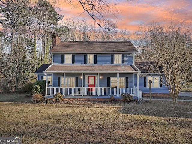 view of front of property with a porch and a yard