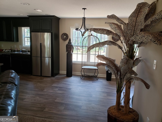 interior space featuring sink, dark wood-type flooring, and a notable chandelier