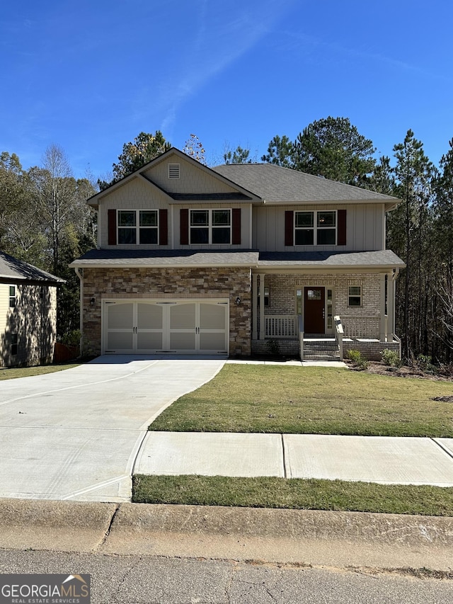 view of front of home with covered porch, a garage, and a front lawn