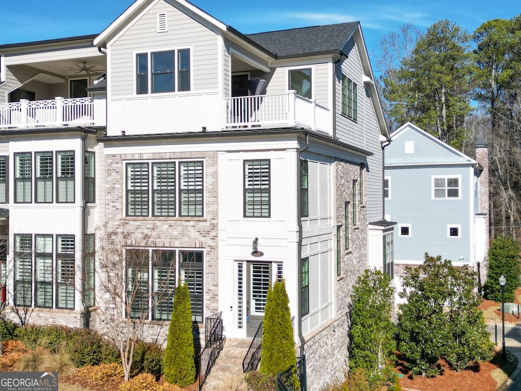 view of front of property featuring a balcony and ceiling fan