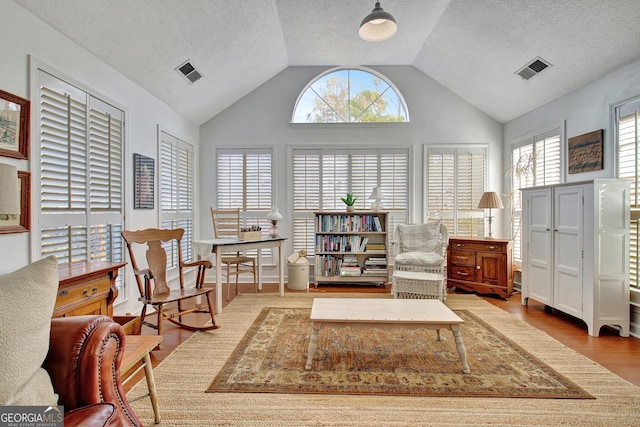 sitting room with hardwood / wood-style flooring and vaulted ceiling