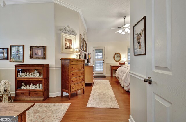 living area with a textured ceiling, hardwood / wood-style floors, and vaulted ceiling