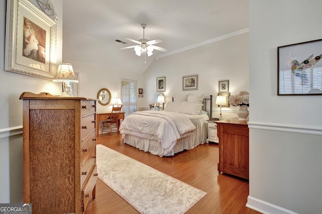 bedroom featuring ceiling fan, light hardwood / wood-style flooring, a textured ceiling, and ornamental molding