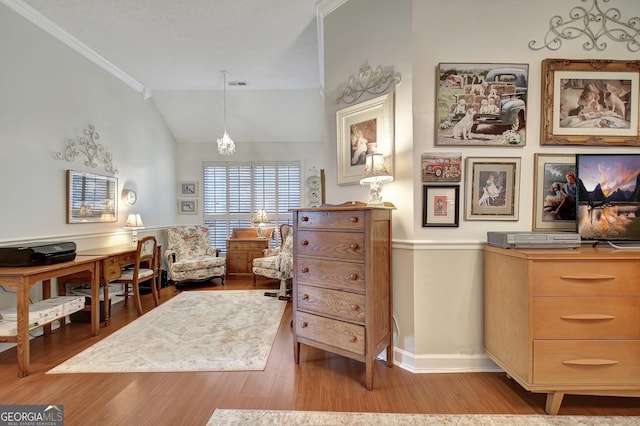 living area with crown molding, light hardwood / wood-style flooring, vaulted ceiling, and an inviting chandelier