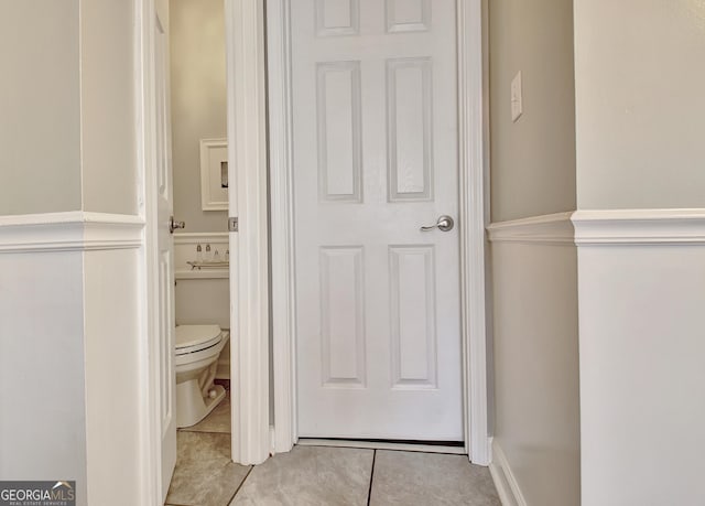 bedroom featuring lofted ceiling, light wood-type flooring, ornamental molding, and connected bathroom