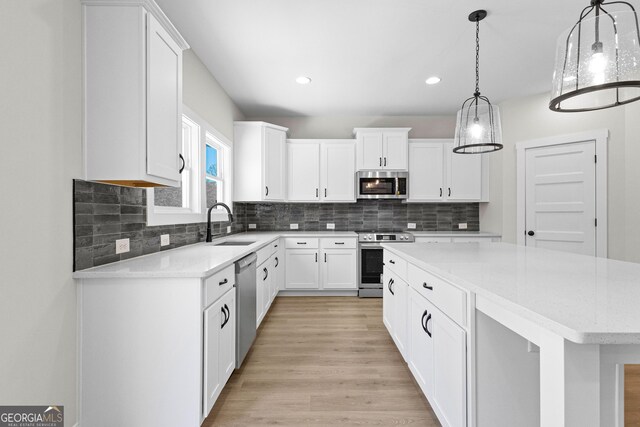 kitchen with white cabinets, a kitchen island, and stainless steel appliances