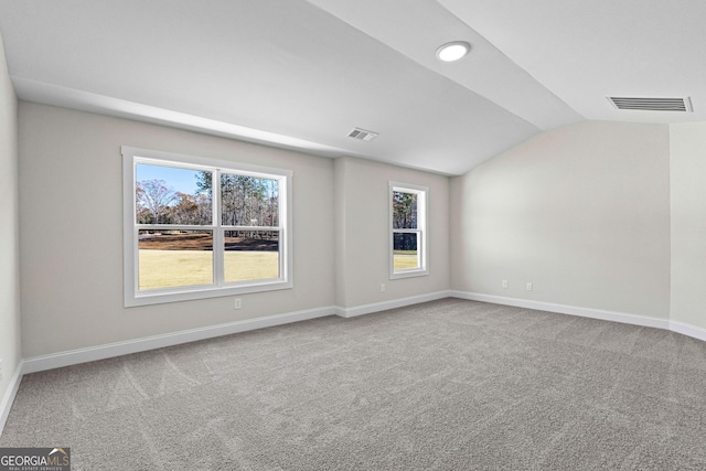 carpeted empty room featuring lofted ceiling