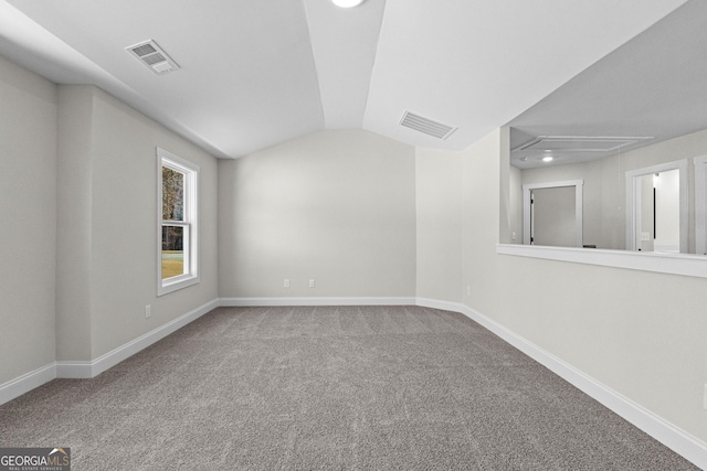 carpeted spare room with lofted ceiling