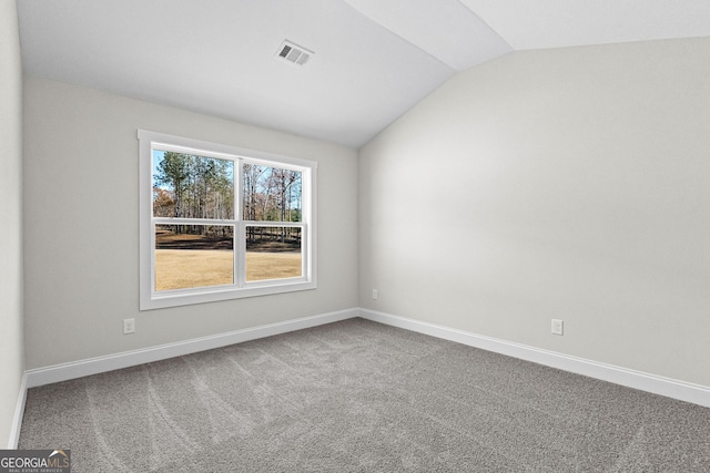 empty room with lofted ceiling and carpet floors