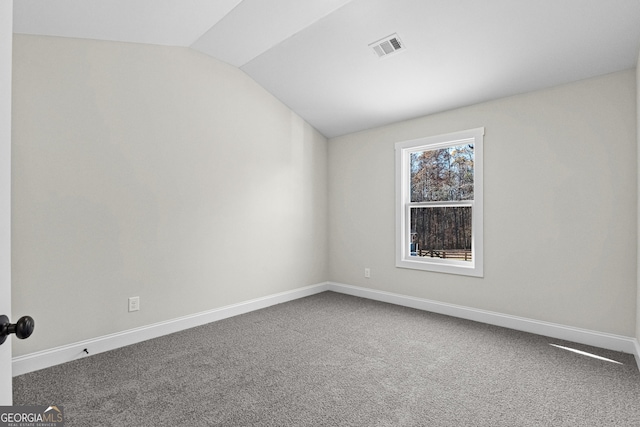 carpeted spare room with lofted ceiling