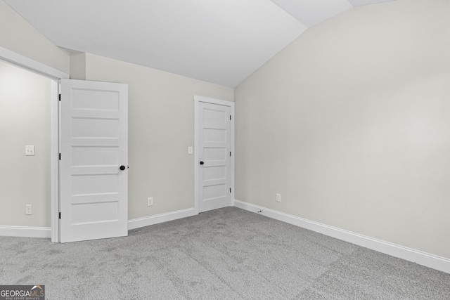 interior space with light colored carpet and lofted ceiling