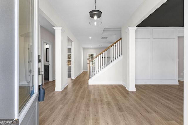 foyer with ornate columns and light hardwood / wood-style flooring