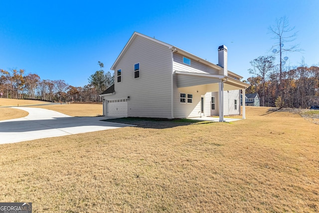 rear view of property with a garage and a lawn