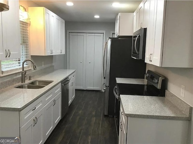 kitchen featuring dishwasher, sink, dark hardwood / wood-style flooring, electric stove, and white cabinets