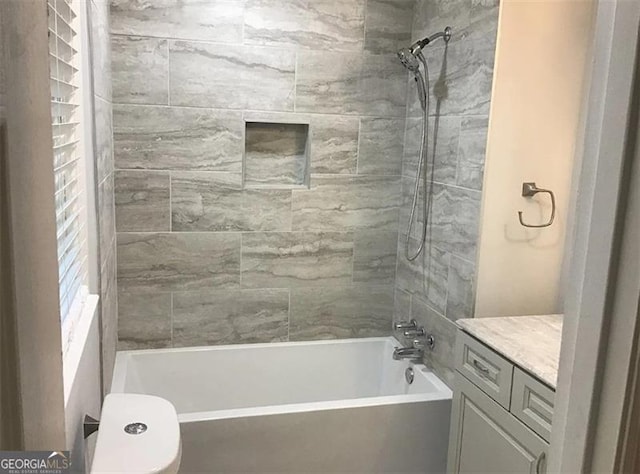 full bathroom featuring vanity, toilet, and tiled shower / bath