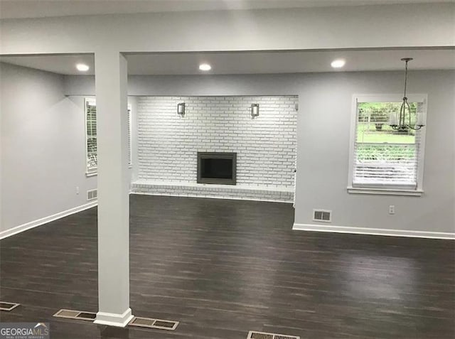 unfurnished living room with dark hardwood / wood-style flooring and a fireplace