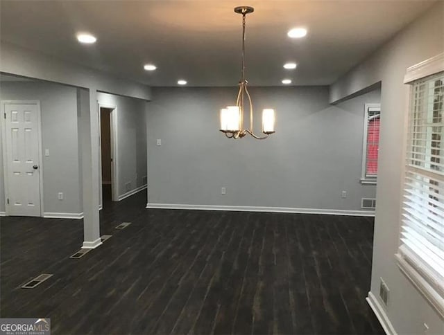 interior space with dark hardwood / wood-style flooring and an inviting chandelier