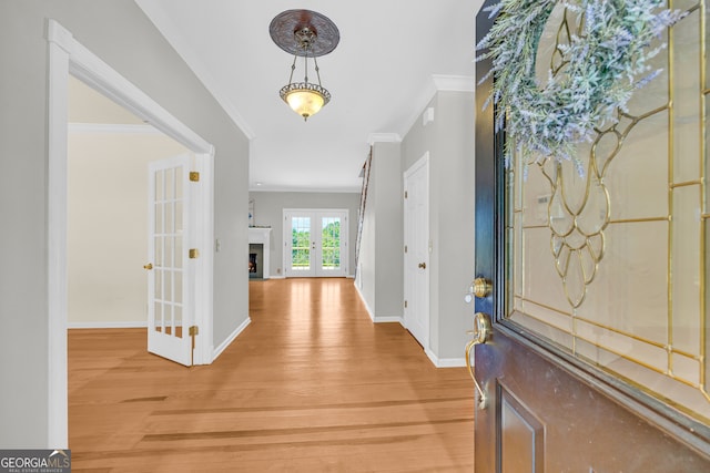 foyer featuring hardwood / wood-style flooring, ornamental molding, and french doors