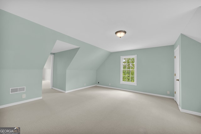 bonus room featuring light carpet and vaulted ceiling