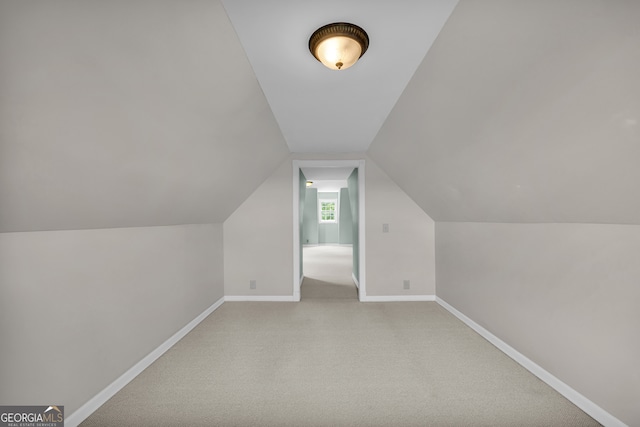 additional living space featuring lofted ceiling and carpet floors