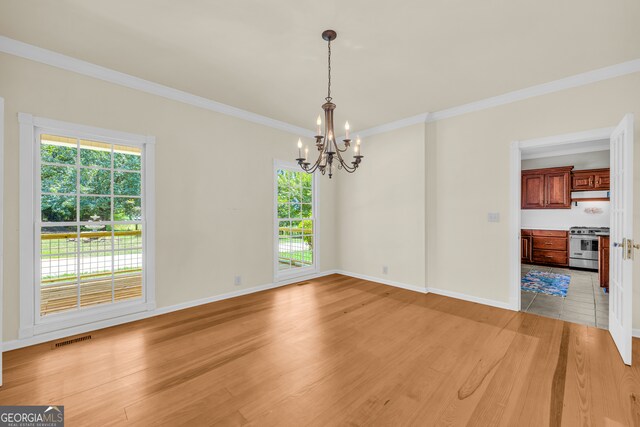 interior space featuring crown molding, light wood-type flooring, and an inviting chandelier