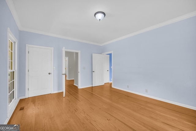 spare room featuring light hardwood / wood-style flooring and ornamental molding