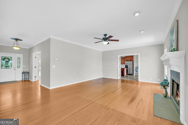 unfurnished living room featuring hardwood / wood-style flooring, ceiling fan, and crown molding