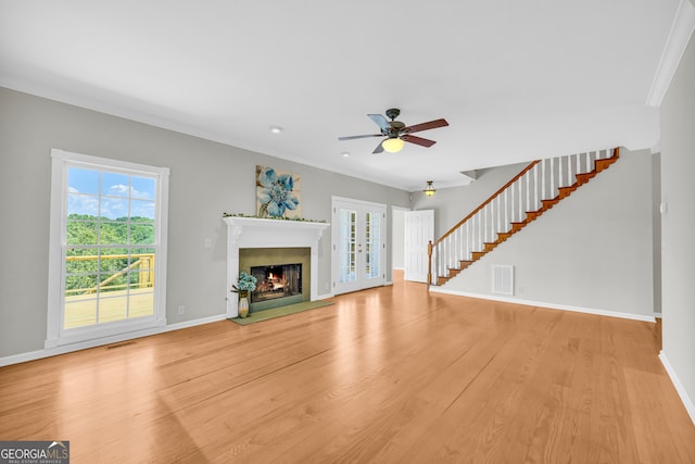 unfurnished living room featuring light hardwood / wood-style floors, ceiling fan, and crown molding