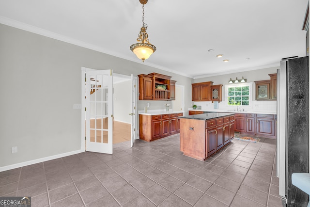 kitchen with stainless steel refrigerator, tile patterned flooring, crown molding, decorative backsplash, and a kitchen island