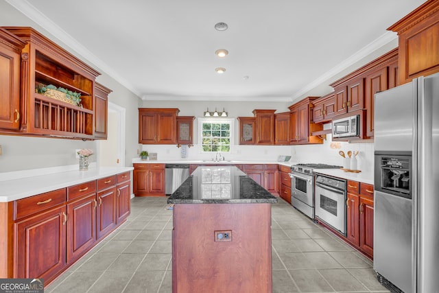 kitchen featuring crown molding, a kitchen island, stainless steel appliances, and light tile patterned floors