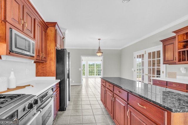 kitchen featuring hanging light fixtures, dark stone countertops, appliances with stainless steel finishes, light tile patterned flooring, and ornamental molding