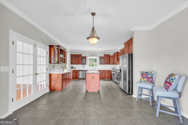 kitchen with appliances with stainless steel finishes, a center island, hanging light fixtures, and ornamental molding