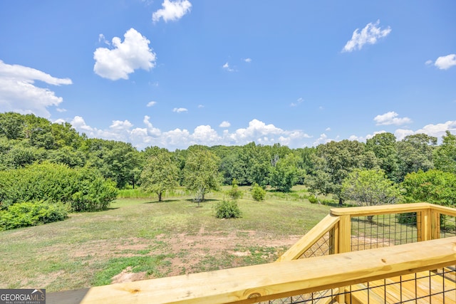 view of yard with a wooden deck and a rural view