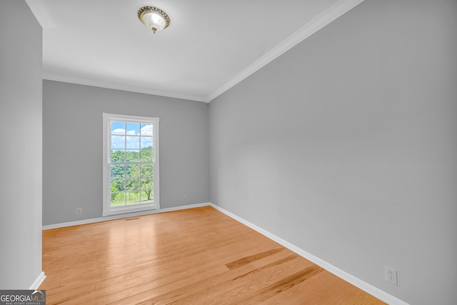 spare room featuring light hardwood / wood-style floors and ornamental molding