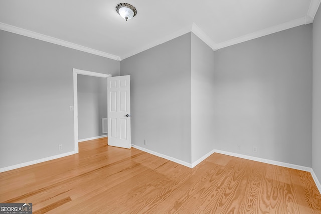 unfurnished room featuring hardwood / wood-style floors and crown molding