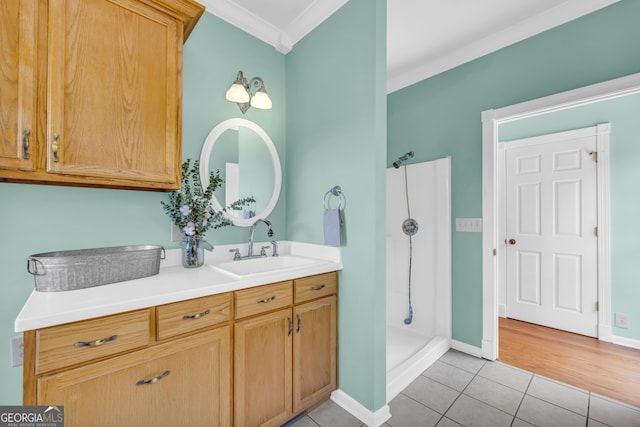 bathroom with tile patterned floors, a shower, vanity, and ornamental molding