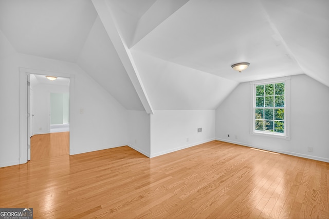 bonus room with light hardwood / wood-style flooring and lofted ceiling